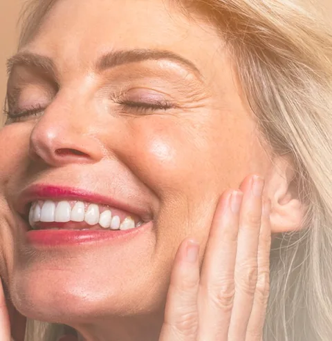Mulher sorrindo com a mão no rosto